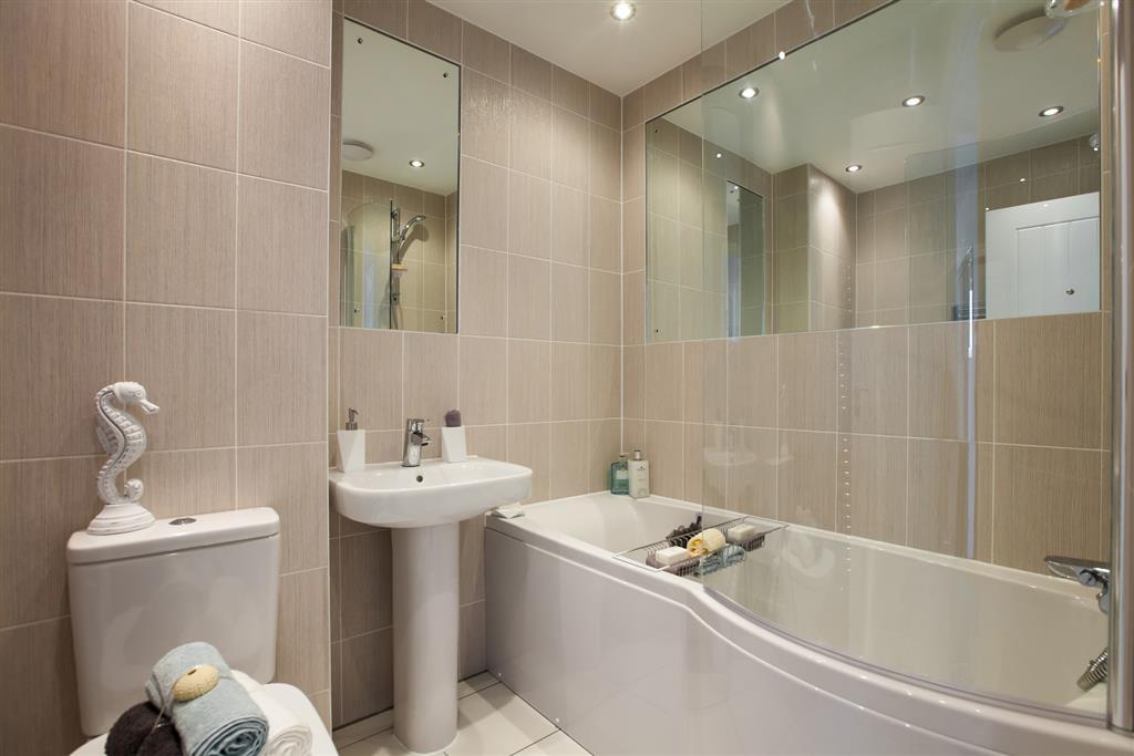 Full height tiling and mirrors set in tiles in the main bathroom