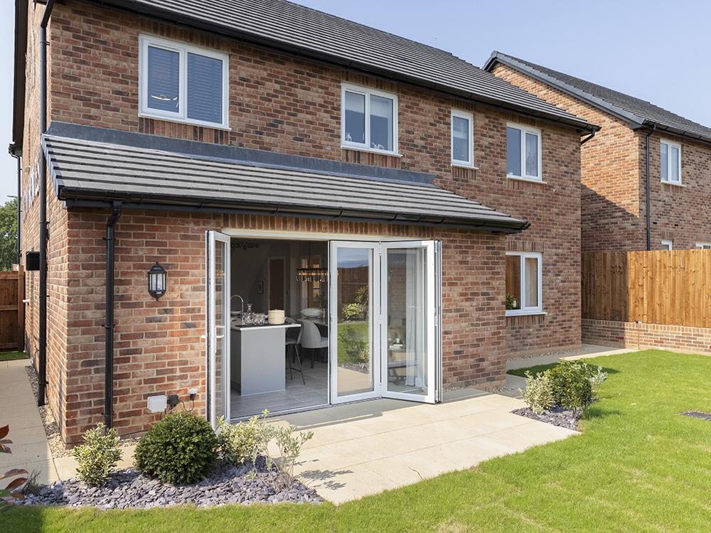 Bi fold doors to a paved patio and turfed garden