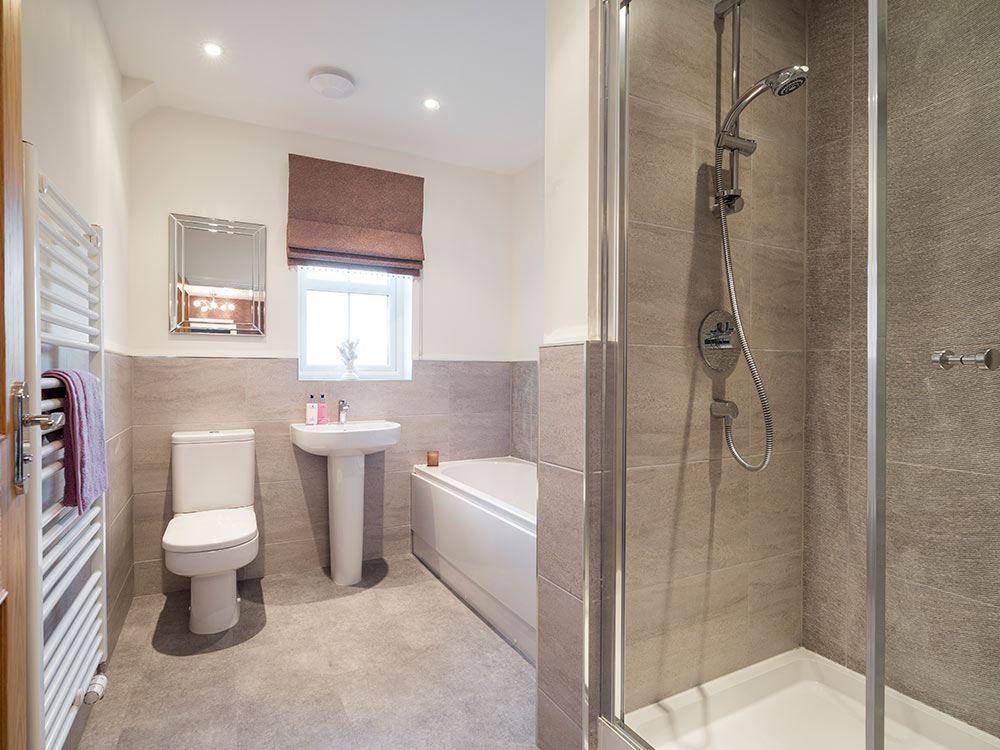 Extensively tiled family bathroom with separate shower cubicle