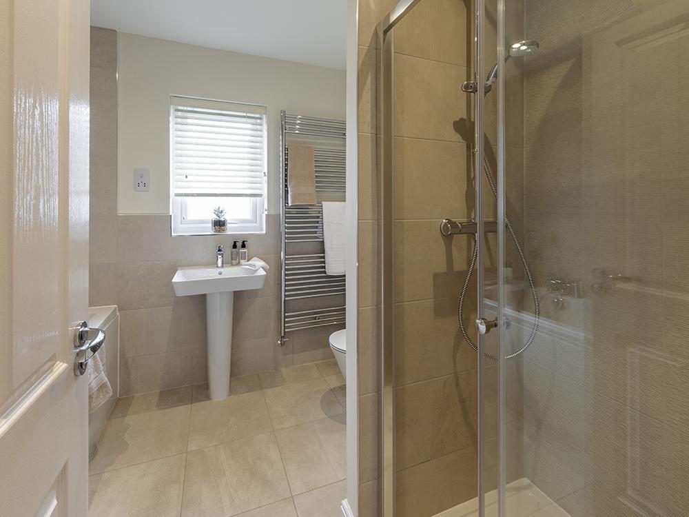 Extensively tiled family bathroom with separate shower