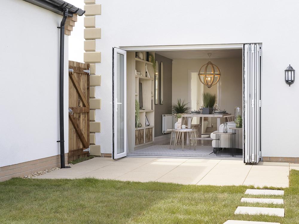 Bi fold doors to a paved patio and turfed rear garden
