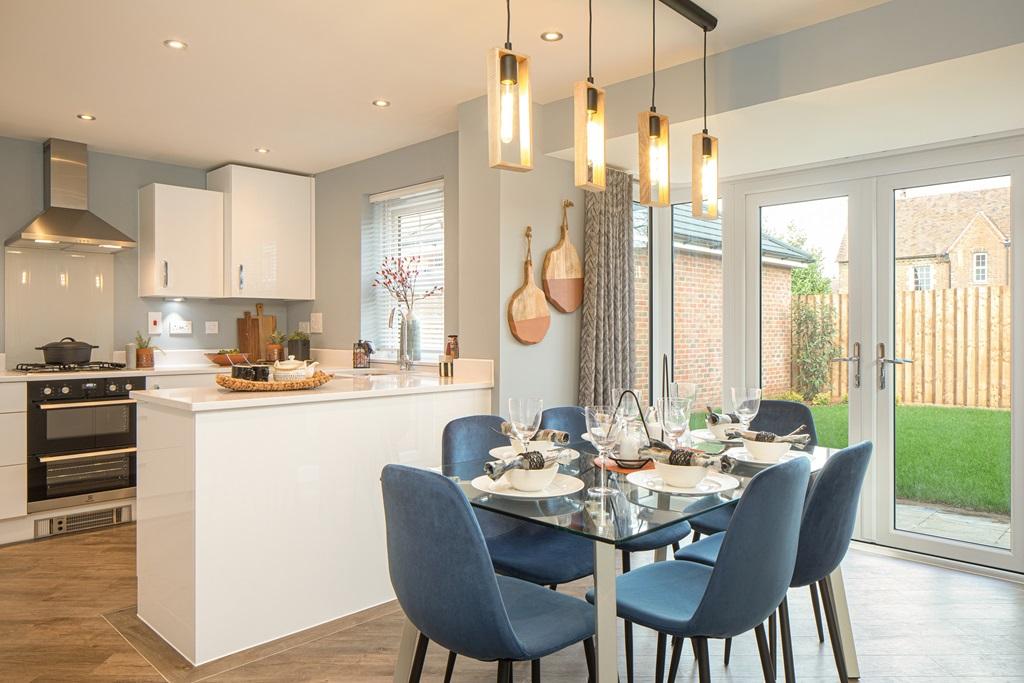 Kitchen diner with French doors to the garden, white kitchen units and blue dining chairs