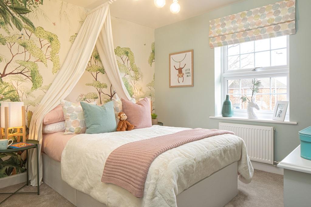 Children's bedroom with tree print wallpaper and white fabric canopy above the bed