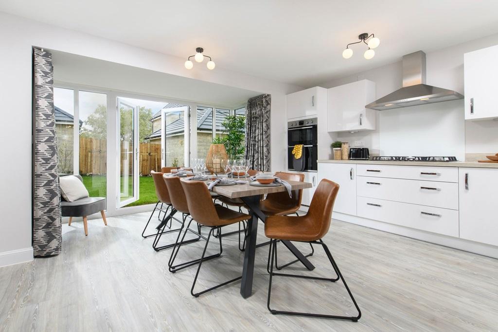 Open-plan kitchen/dining area with glazed bay leading onto garden - Millford style home