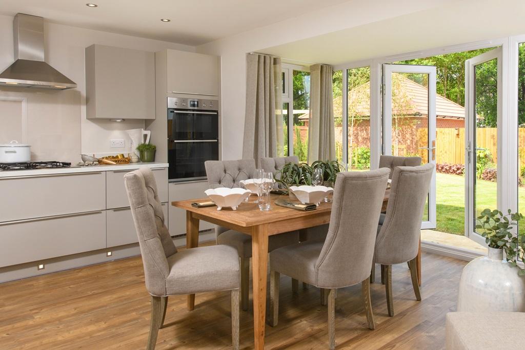 Open-plan kitchen with integrated appliances, dining area &amp; family room with French doors leading on