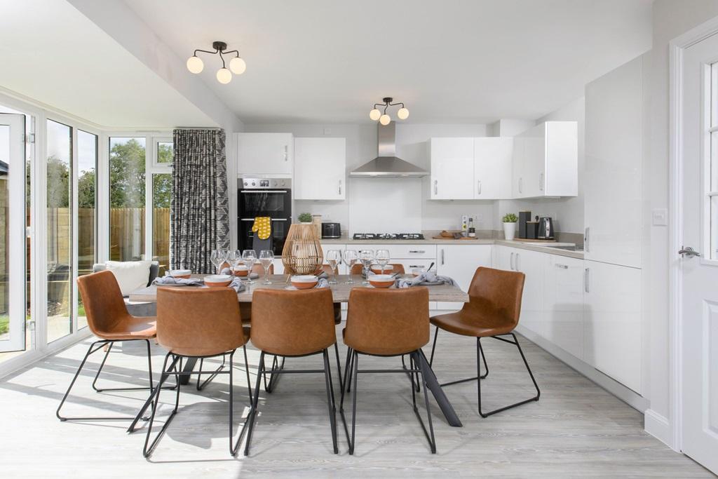 Open-plan kitchen/dining area with glazed bay leading onto garden - Millford style home