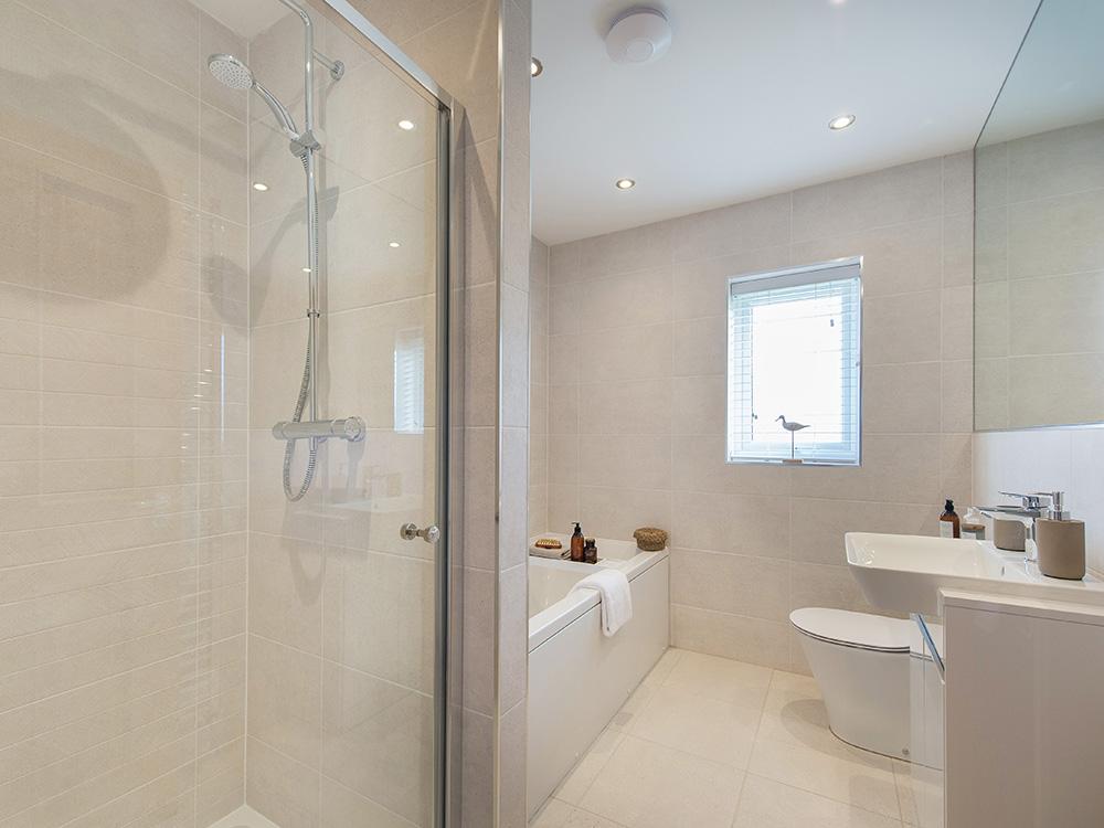 Extensively tiled family bathroom with separate shower