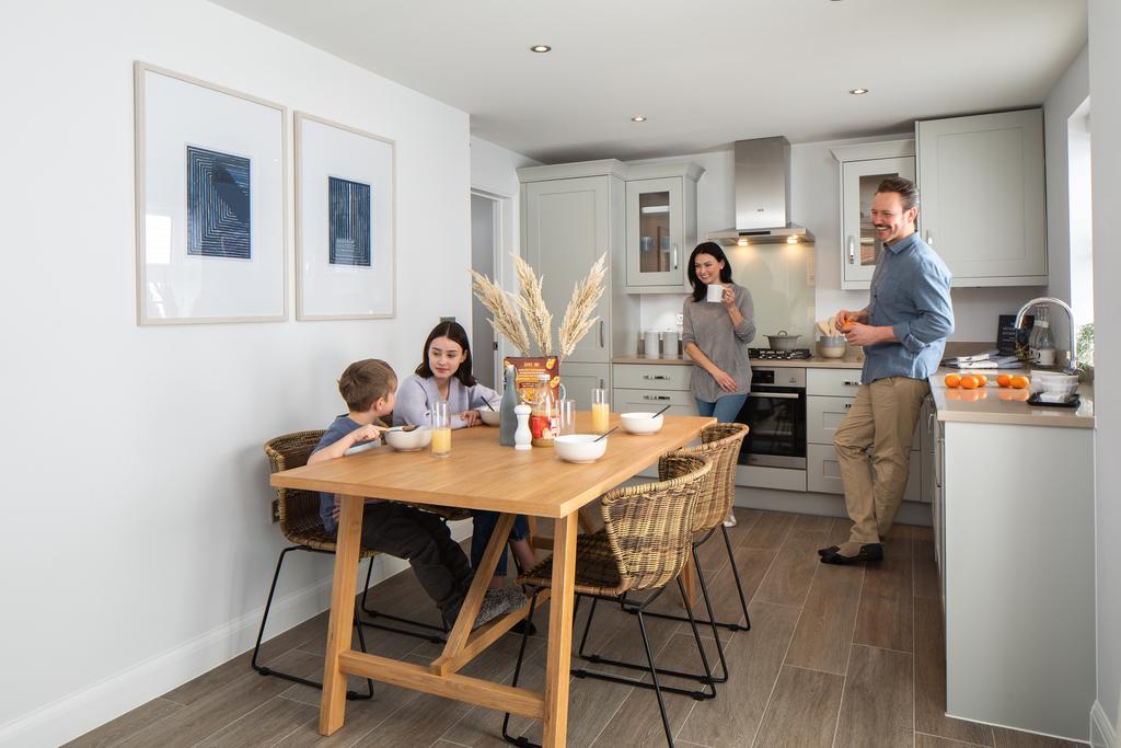 Open plan kitchen with family sat around table, hadley, 3 bed house type