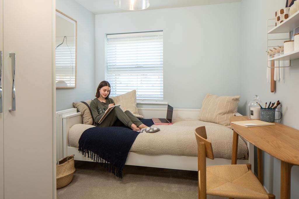Girl reading in single bedroom, hadley, 3 bed house type