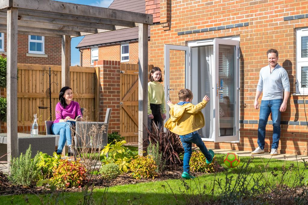Family playing outside in garden, hadley, 3 bed house type