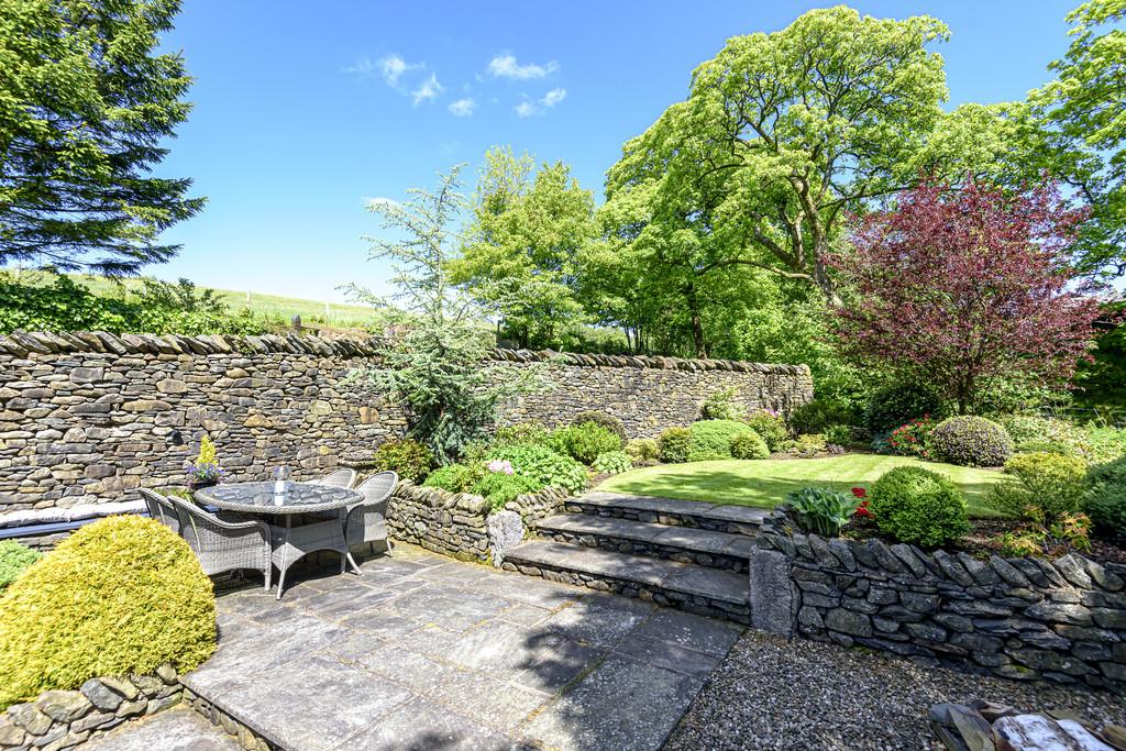 Sheltered patio with steps to lawned garden
