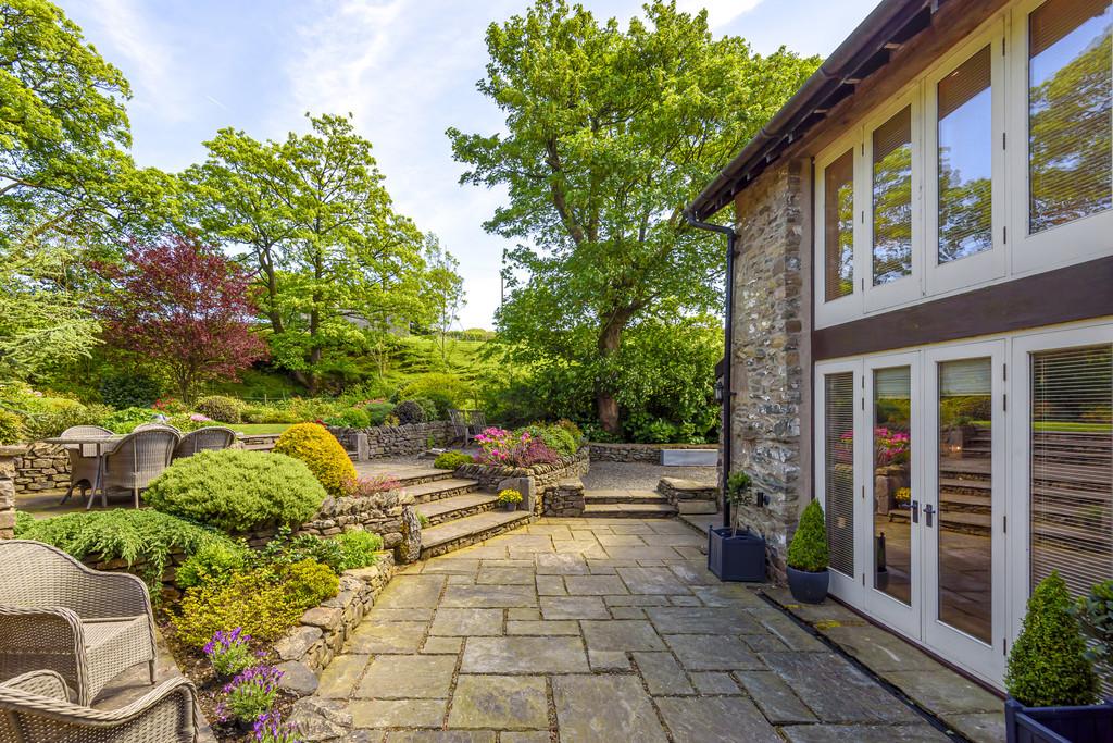 Paved courtyard with steps to upper patio and gard