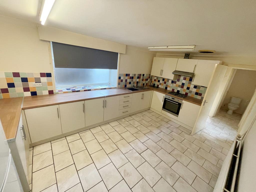 Kitchen with units and tiled floor