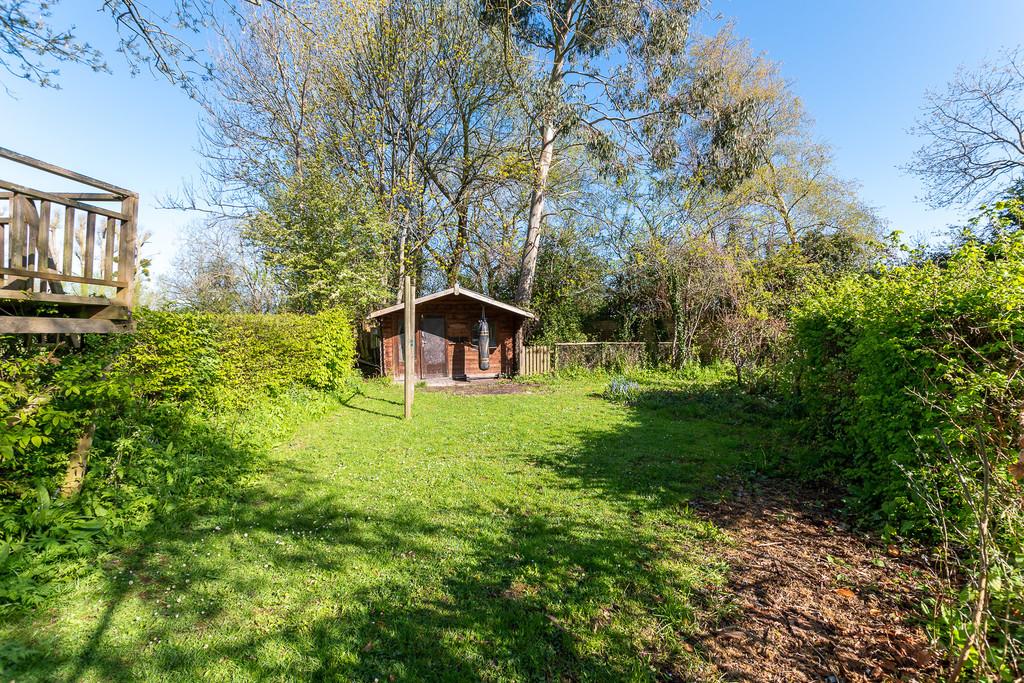 Large wooden summerhouse to end of garden