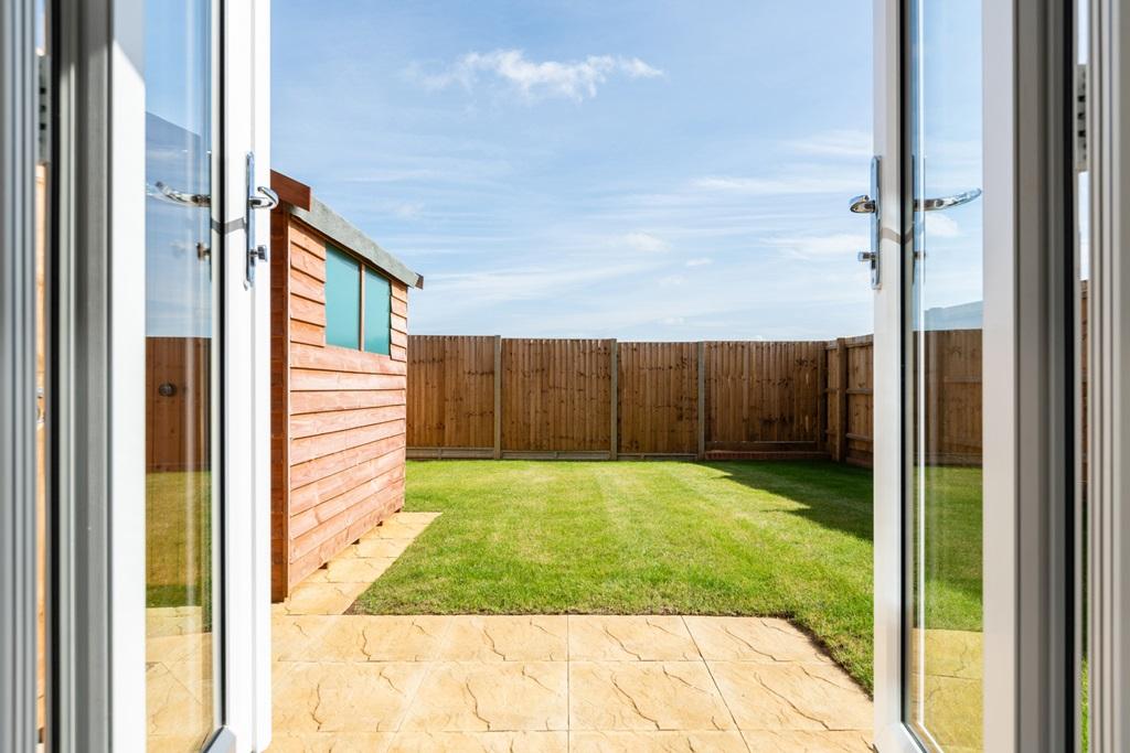 French doors lead to the turfed garden