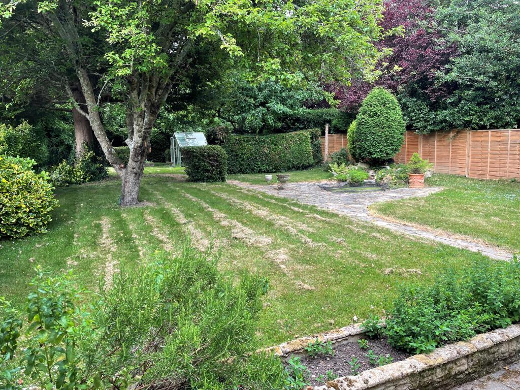 Large rear garden with sheds and water feature