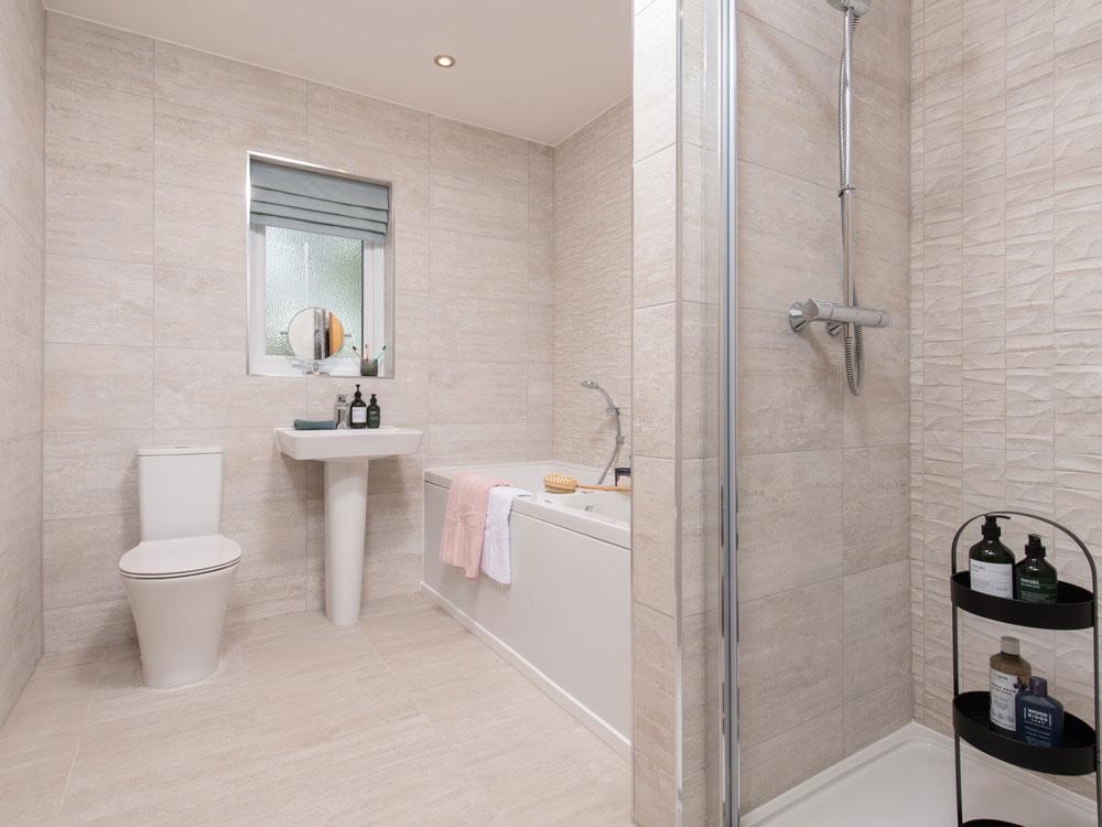 Extensively tiled family bathroom with separate...