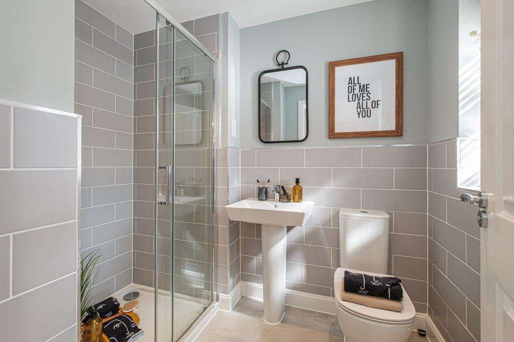 Grey tiled en suite shower room in an Exeter home
