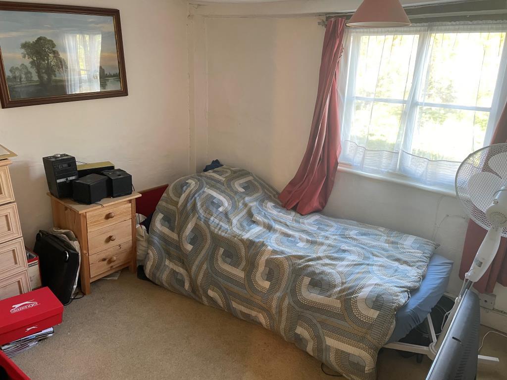 Bedroom with window overlooking rear of property