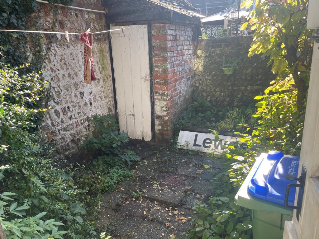 Walled patio garden with brick shed