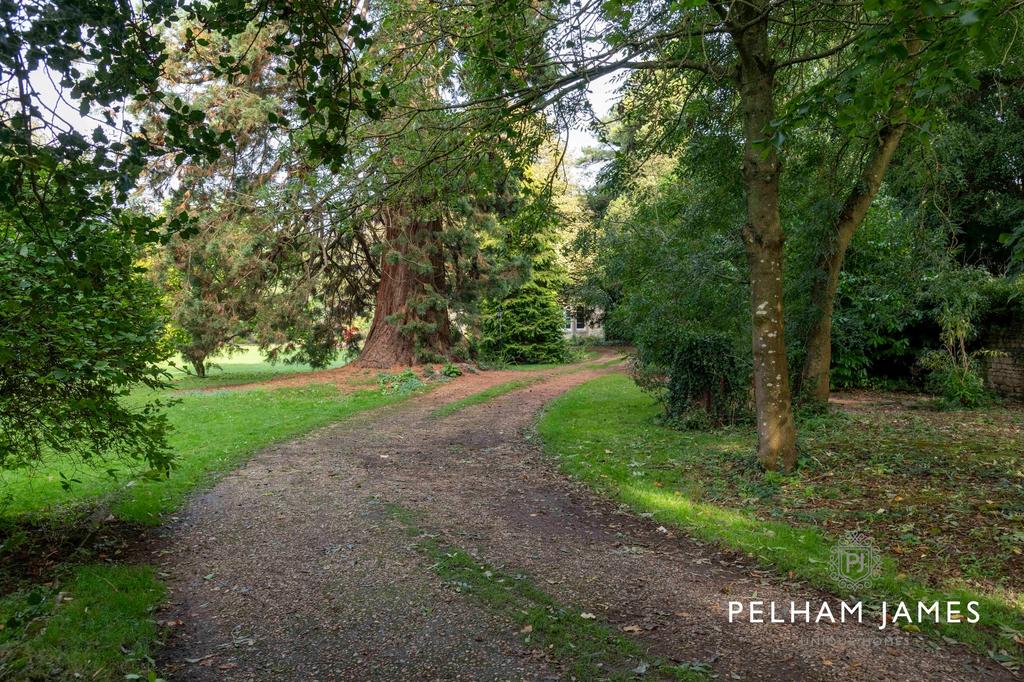 Gated gravel driveway to Greetham House,...