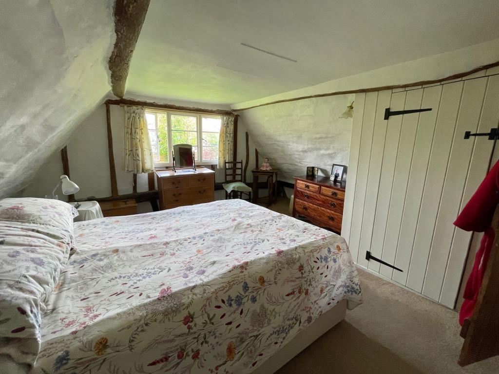 Bedroom 2 with exposed beams and window to side