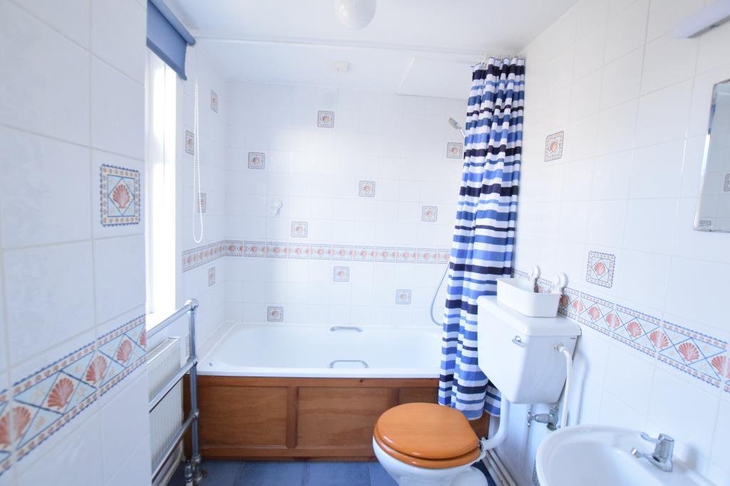 Bathroom with shower over bath and tiled walls
