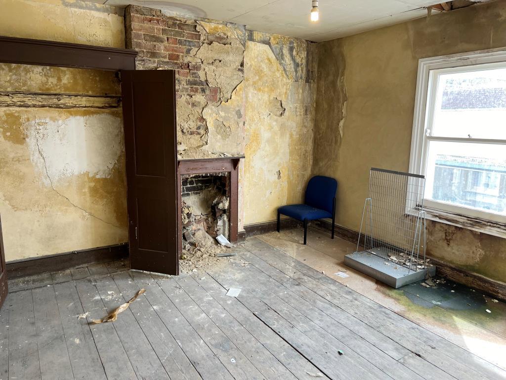 Room needing refurbishment with bare floorboards a