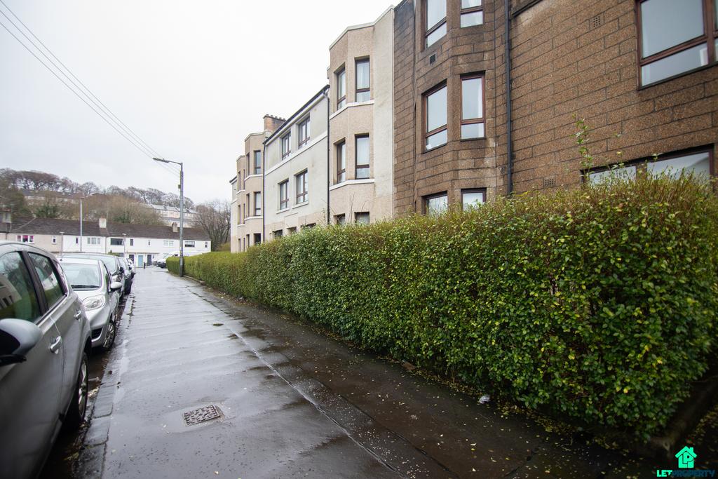 Street scene with property, parking