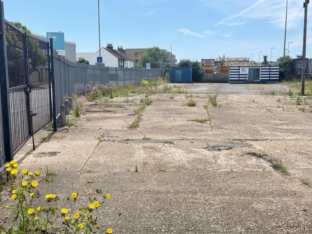 Vacant site with hardstanding area and gate