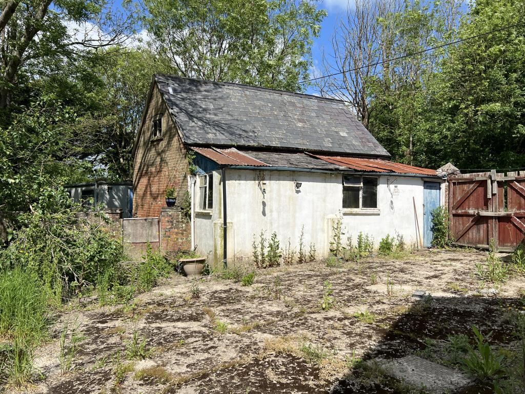 Concrete patio in rear garden with garage and gate