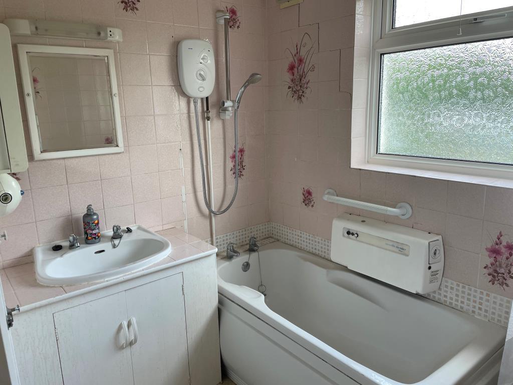 Bathroom with sink and bath with shower