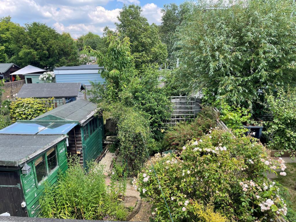 View of rear gar from first floor with sheds and f