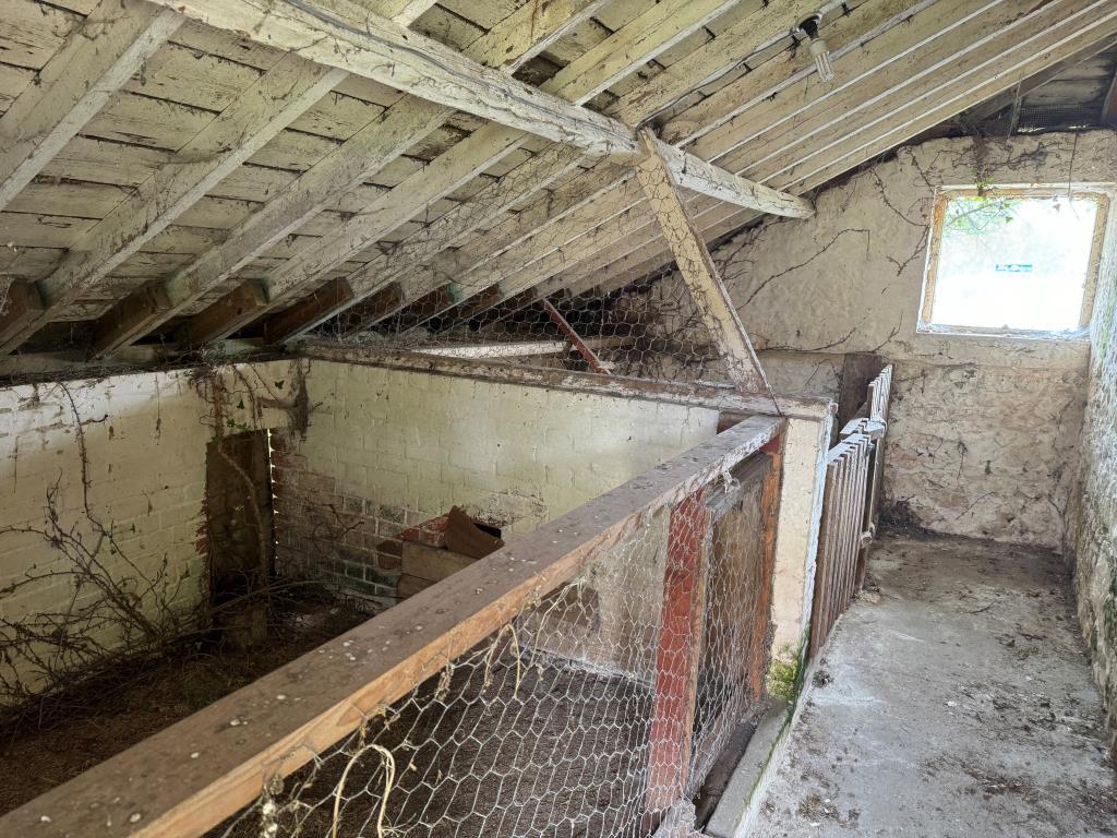 The pig pens attached to the roadside barn