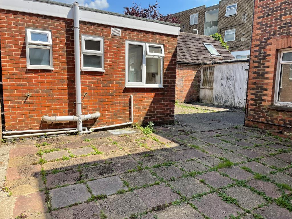 View of paved courtyard area from garage