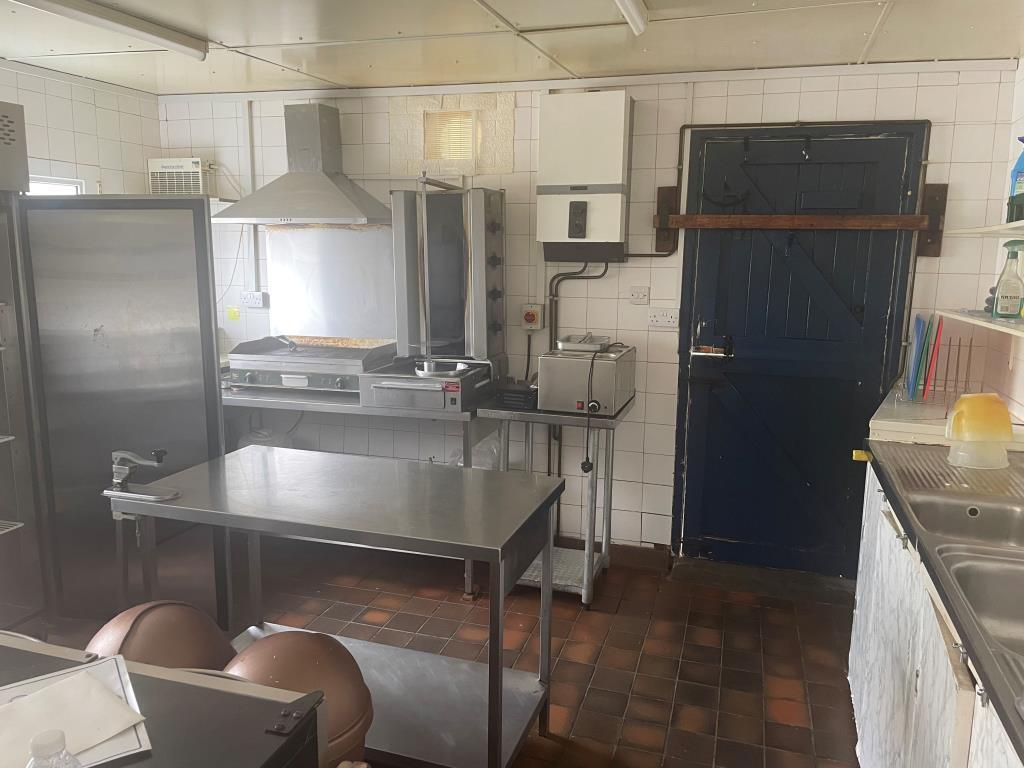 Commercial kitchen with door leading to side area