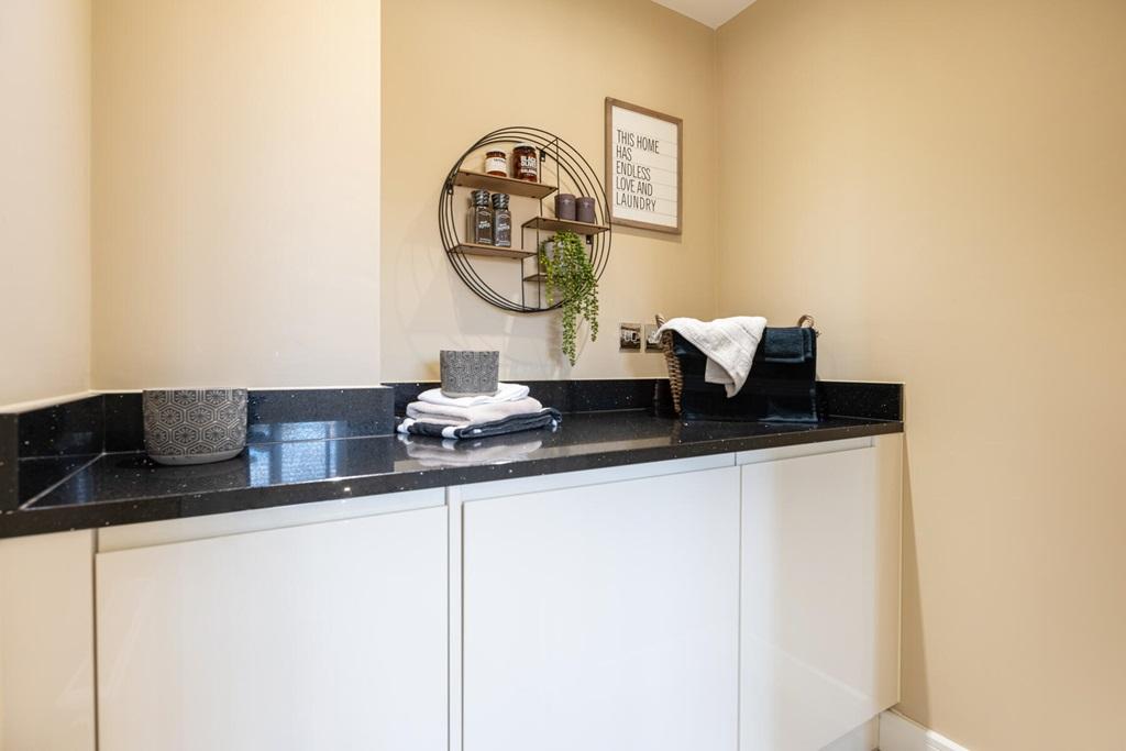 A handy utility rooms sits just off the kitchen