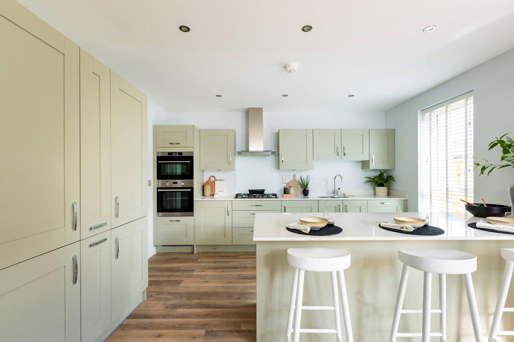 The modern kitchen/diner with doors out to the...