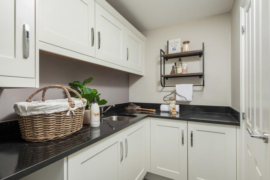 Holden utility room with white cabinets and...