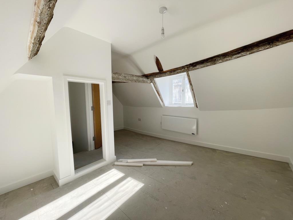 Second floor bedroom with exposed beam in Flat A