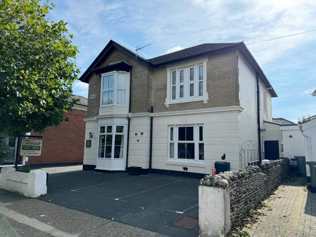 Detached building with painted render and brickwor