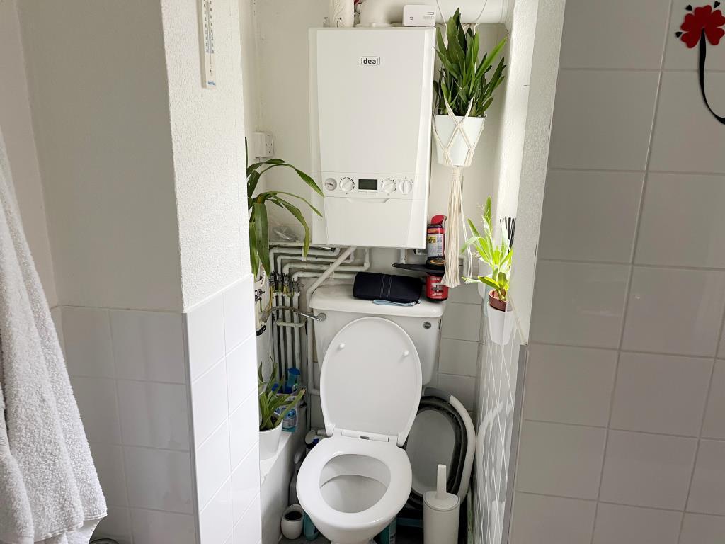 White WC with gas bioler above