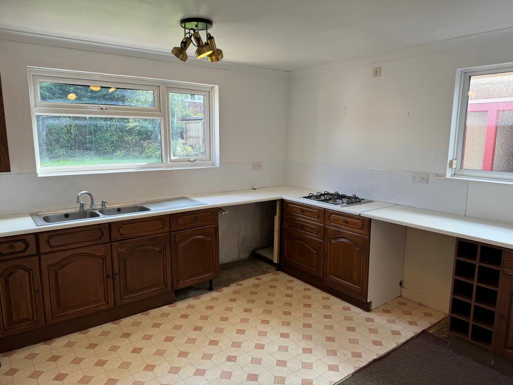 Kitchen with units laminate flooring and view to g