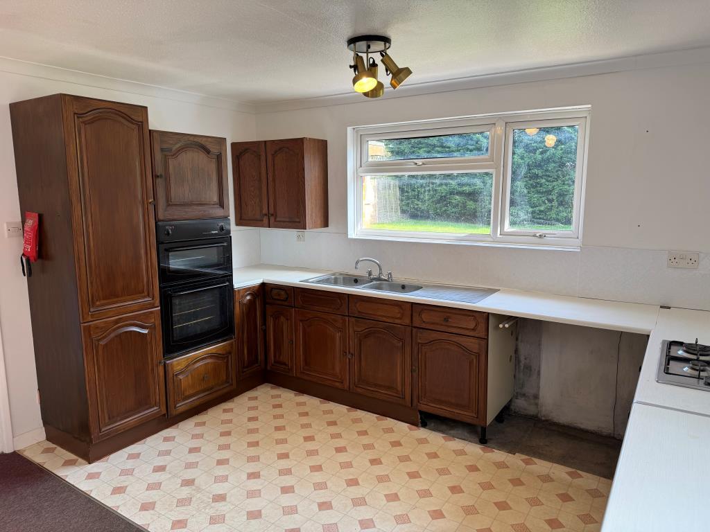 Kitchen with units laminate flooring and view to g