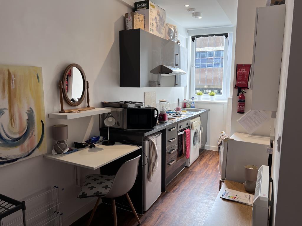 Fitted kitchen units with white painted walls