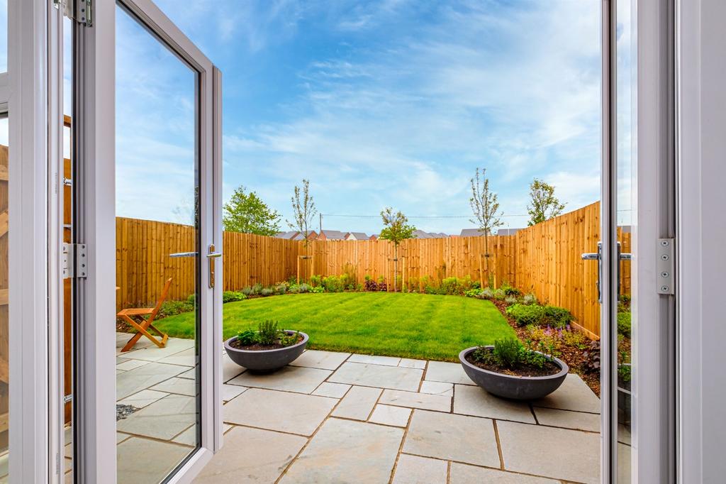 Open French doors to a patio and lawn