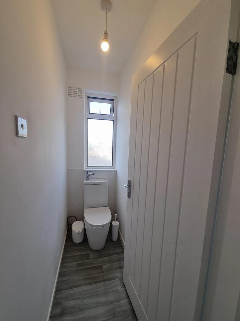 A clean and tidy single toilet with natural lig...