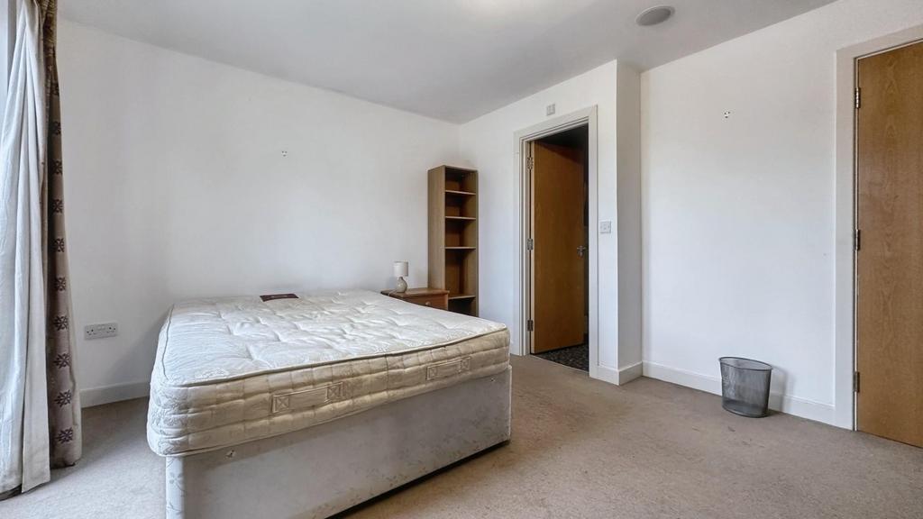 A partially furnished double bedroom with a mat...