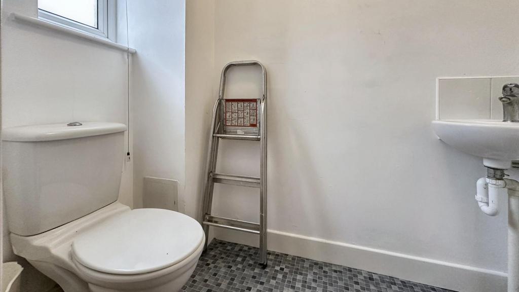 A clean but small bathroom featuring a shower a...