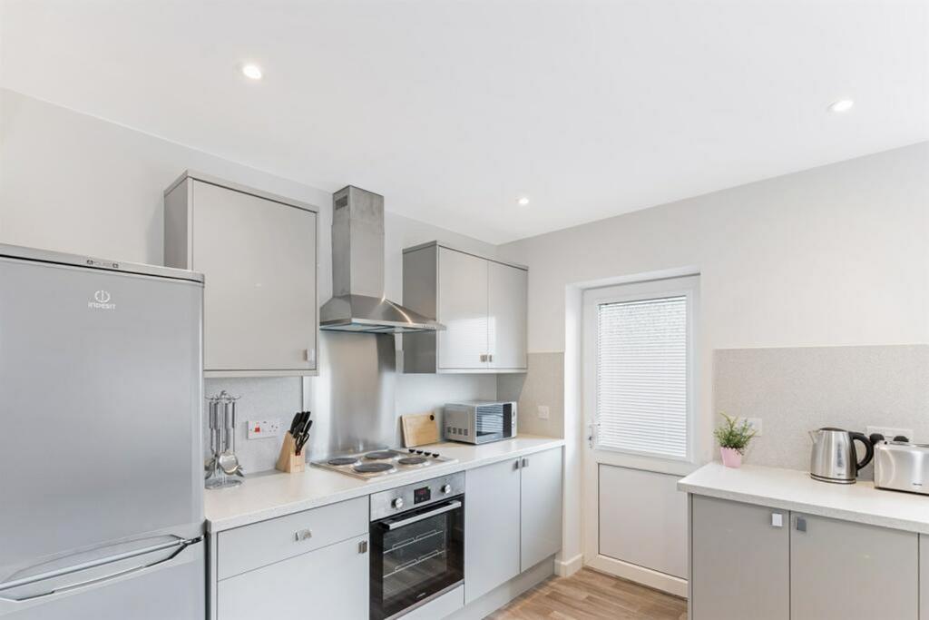 A clean and modern kitchen featuring sleek cabi...